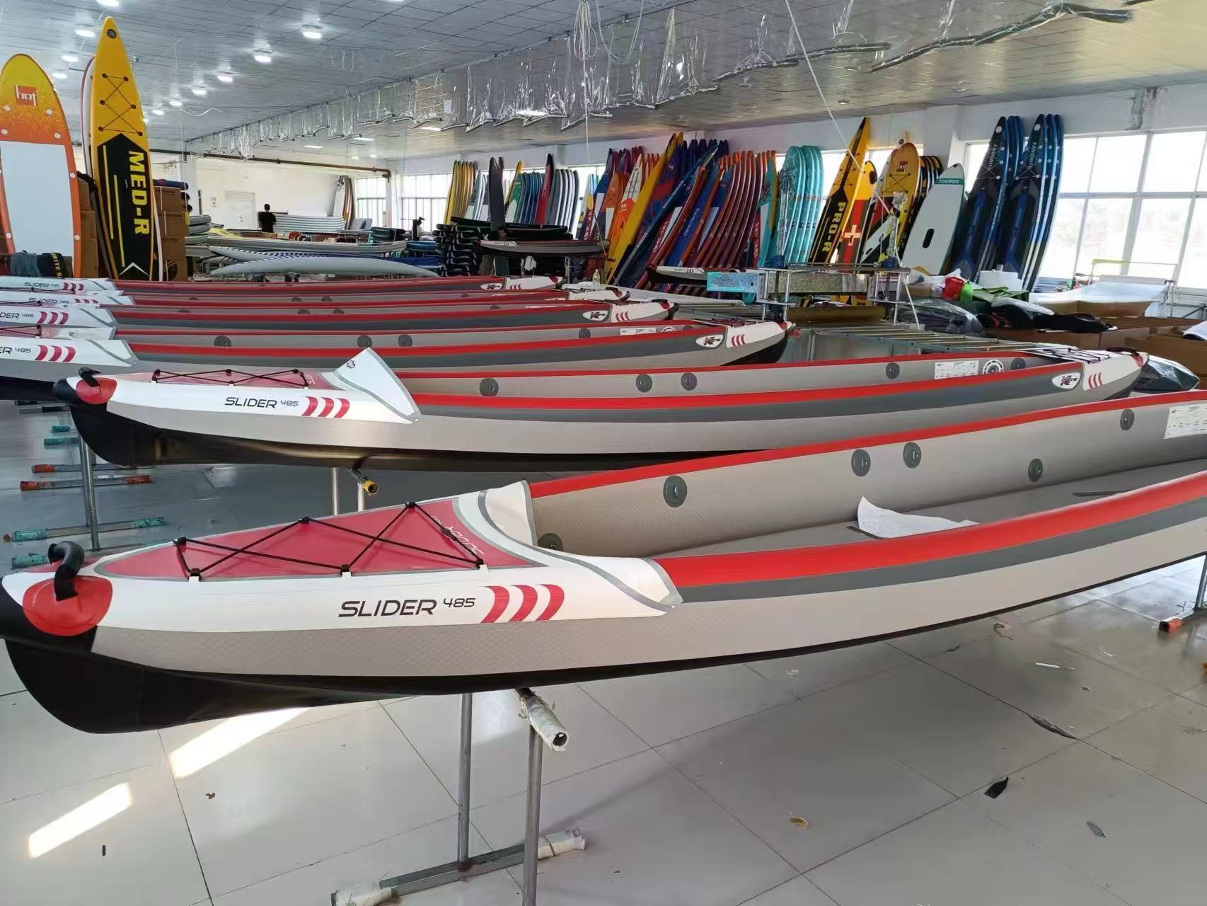 Factory showroom displaying finished red and white inflatable paddle boards ready for wholesale shipping