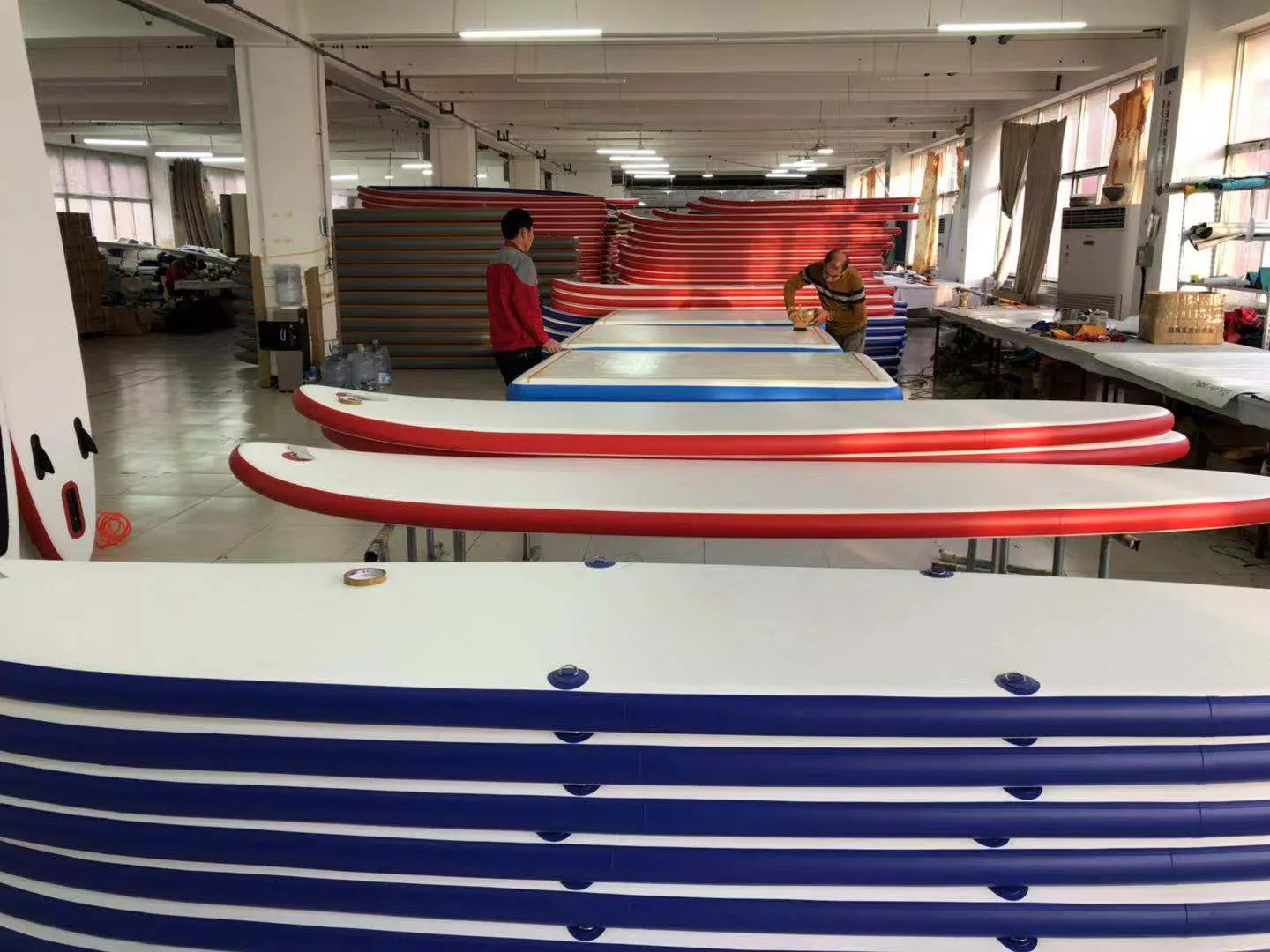 Inflatable SUP factory production line with red and blue paddle boards for private label manufacturing