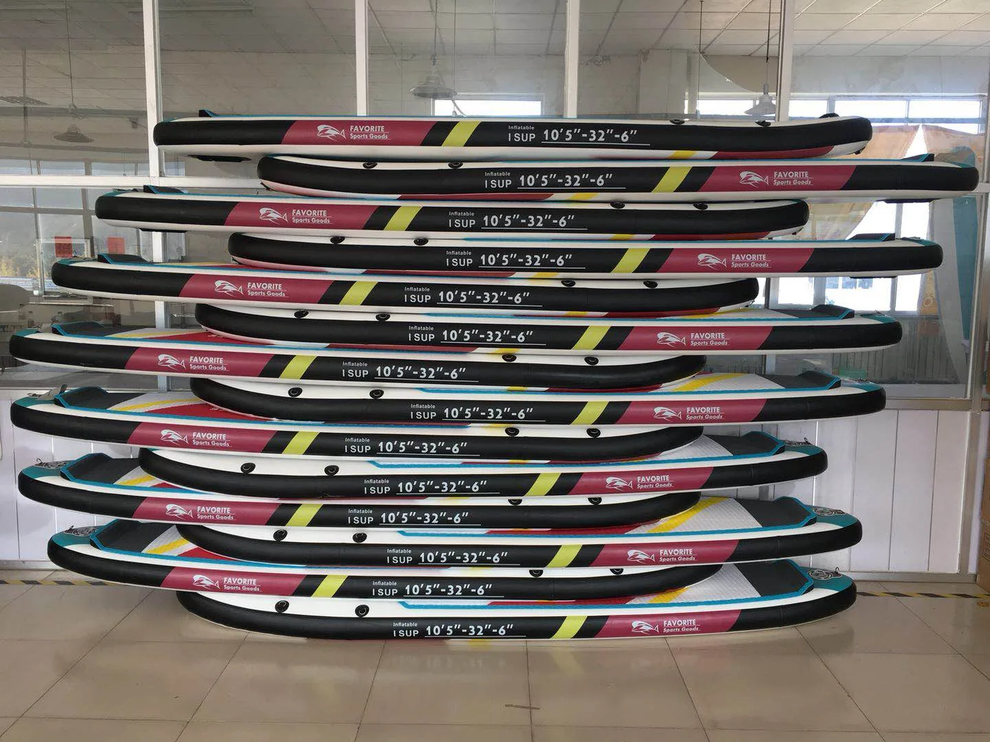 Inflatable SUP paddle boards lined up on a factory storage rack