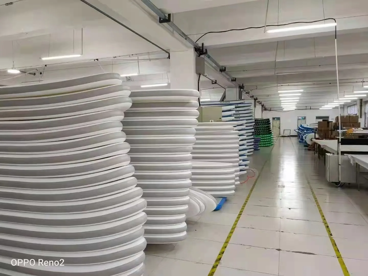 Inflatable SUP boards stacked on a factory rack before packing for export